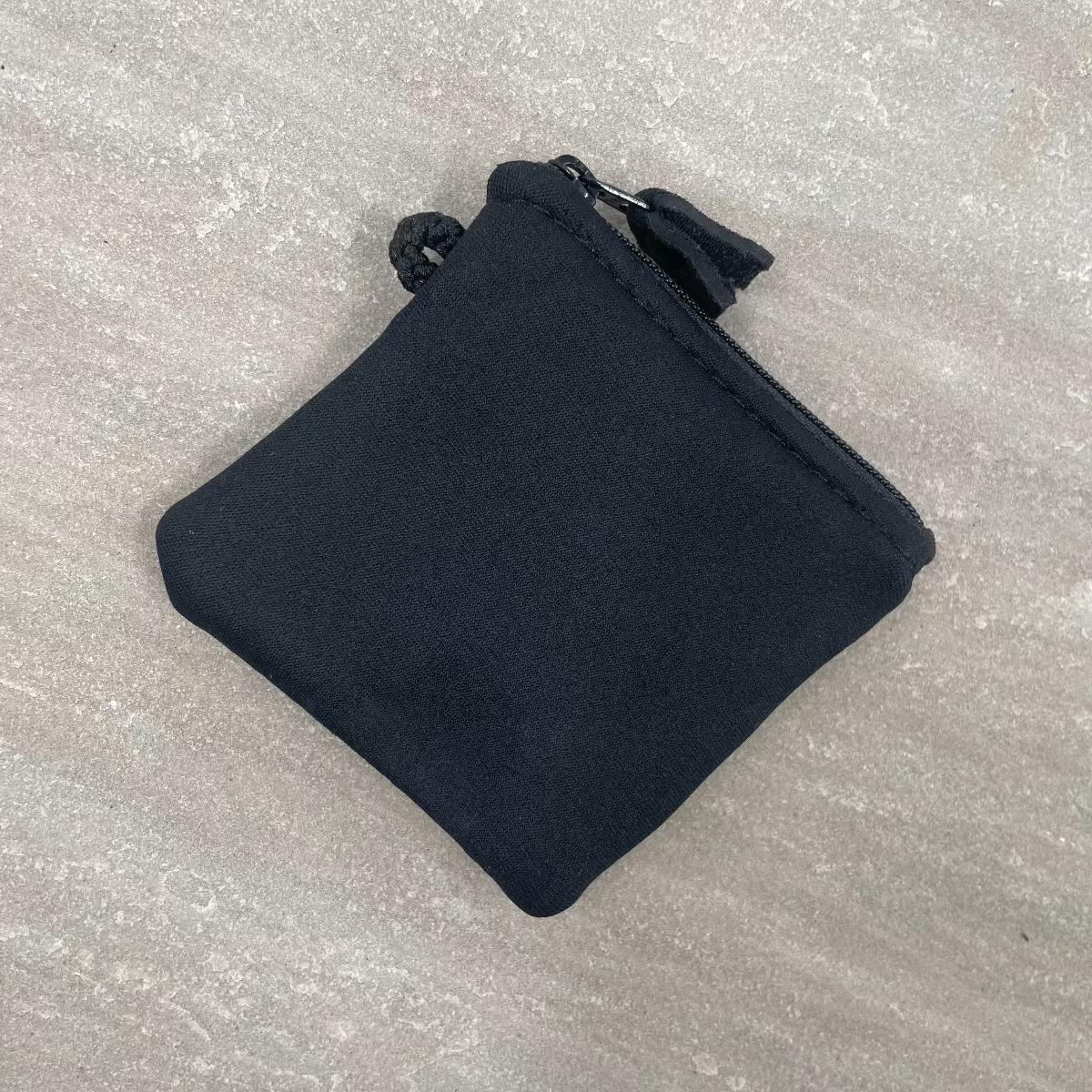 Black pouch on a textured gray surface