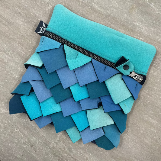 Blue fabric pouch with a zipper on a gray surface