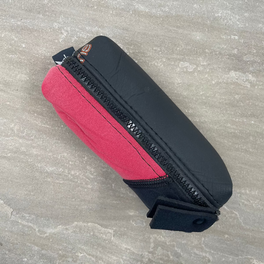 Black and red pouch with zipper on a gray surface